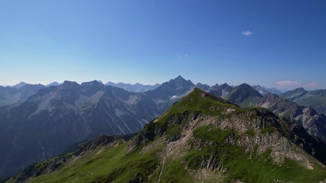 4K Aerial Drone video of the most beautiful mountain lake Schrecksee in Bavarian Alps with the cows feeding on lush green grass on a sunny day with blue skies and rocky hill tops surrounding