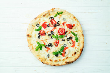 Pizza with mozzarella cheese , olives , chicken , pineapple , basil and tomatoes