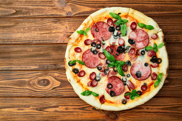 Pizza with mozzarella cheese , salami sausages , olives , and basil