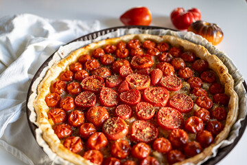 Delicious homemade rustic open pie (galette) with cherry tomatoes and tapenade (olive paste). top view