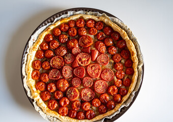 Delicious homemade rustic open pie (galette) with cherry tomatoes and tapenade (olive paste). top view