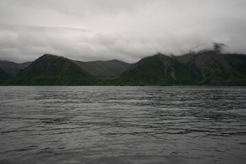 A bay surrounded by snow-capped mountains and dotted with ice formations. The magic of nature in its frozen splendor. A unique combination of ice and sea.Travel in cold weather, fresh air