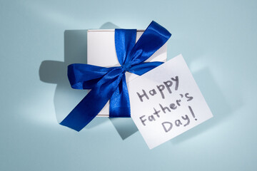 Happy Father’s day concept. Gift box with blue ribbon bow and Happy Father's day label on color background. Father's day banner design