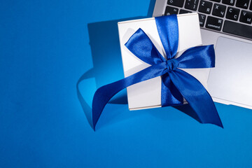 Gift box with a bow on a colored background. Happy Holidays, gift box close-up. Boxing Day...