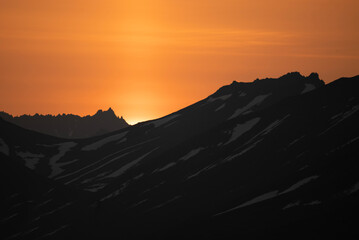 Stunning sunset over mountains and sea on wild natural islands in the northern region of the world, a journey to the cold and fiery sunsets of nature