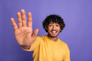 Photo of cheerful positive man wear trendy yellow clothes arm hello isolated on violet color...