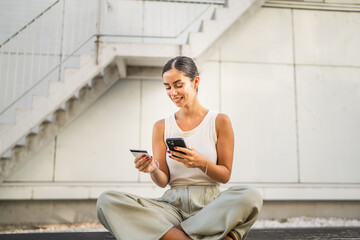 Young woman sit outdoor and buy online on cellphone with credit card
