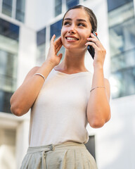 Portrait of young woman talk on mobile phone in front building