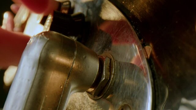 Hand of musician plugging cable jack into input socket on electric guitar, then adjusting tone knob. Macro shot