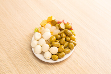 dish with quail egg, olives, pepperoni and onion

