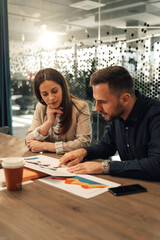 Marketing experts analyzing global market and charts at boardroom.
