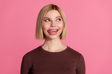 Obraz premium Photo of lovely dreamy cute girl wear trendy brown clothes lick teeth empty space isolated on pink color background