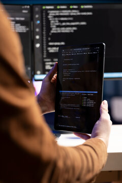 Teleworking programmer designing and developing software applications using tablet. IT administrator implementing and maintaining company systems using portable device, close up