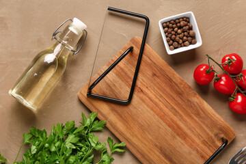 Composition with wooden kitchen board, spices, oil, parsley and tomatoes on color background