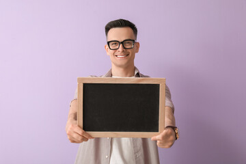 Male teacher with chalkboard on lilac background