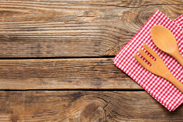 Folded napkin with cutlery on wooden background