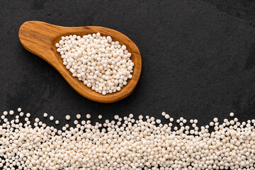 Tapioca pearls from cassava root - White sagu balls on the spoon. Manihot esculenta.