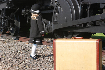 Little girl, person with locomotive and suitcase