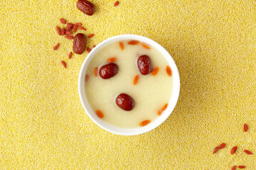 Close-up of porridge of red dates and wolfberries, millets background, top view