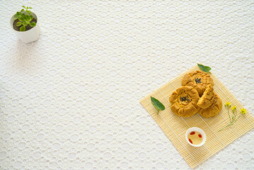 Close-up of egg shortbread, goji tea, small potted plant, top view