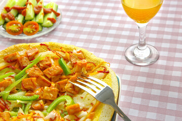Close-up delicious pizza, juice, tomato on gingham pattern background