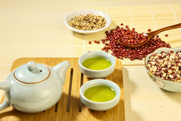 Close-up of red beans, pinto beans and other grains on a wooden board, green tea