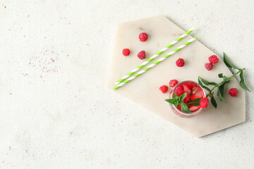 Glass of fresh raspberry lemonade with mint on white background