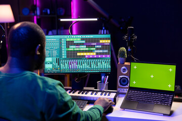Music producer mixing and mastering songs on digital post production pc interface, greenscreen...