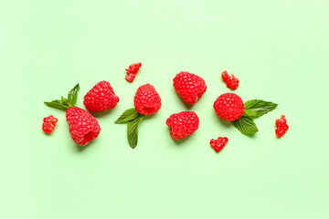 Fresh raspberries and mint on green background