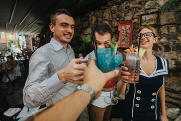 A group of friends celebrating with vibrant cocktails at an outdoor cafe. The atmosphere is joyful and relaxed, highlighting friendship and leisure.