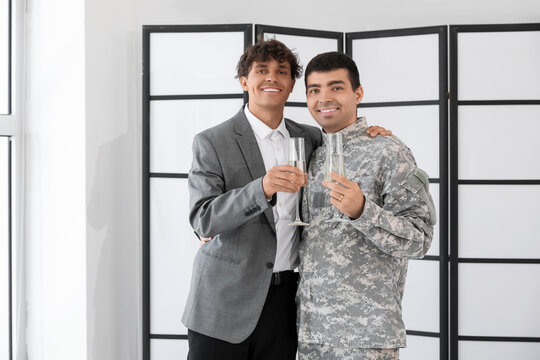 Soldier with his husband and glasses of champagne on their wedding day