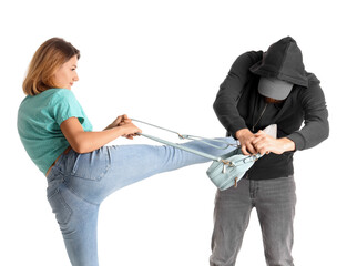 Young woman defending herself against robber on white background