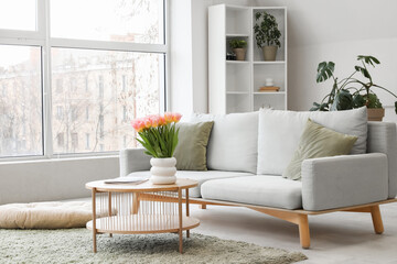 Stylish sofa with coffee table in light living room