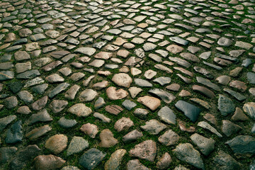 Pavement road. Stone cladding. Rough brick road. Cobblestone pavement background. Textured background. Sidewalk. Road. Old cobblestone road.