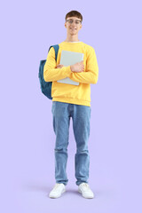 Male student with laptop on lilac background