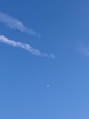 Blue sky with white airplane streaks across