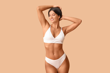 Obraz premium Beautiful young happy body positive woman in underwear on beige background