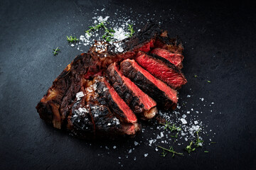 Barbecue dry aged chianina rib of beef steak served with crystal salt and thyme as close-up on a...