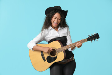 African-American cowgirl playing guitar on blue background