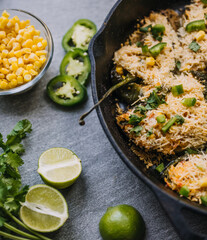 Poblano peppers in a cast iron skillet with garnishes 