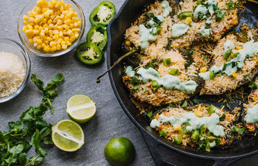 Chicken stuffed poblano peppers with corn and rice, garnished with cilantro lime