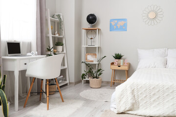 Interior of light teenager's room with bed, shelf units and study table