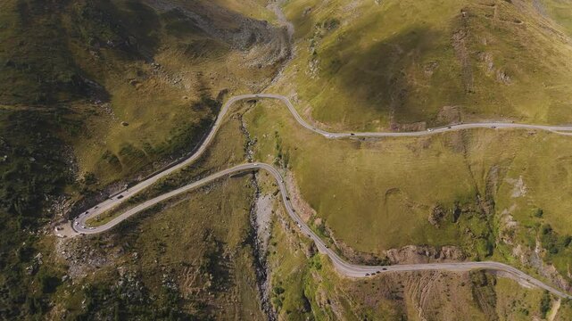 Top cinematic aerial view to the Transfagarasan famous curvy road in Romania. Aerial view of Transfăgărașa road in Fagarash Mountain. Romanian wild nature and landscape. 