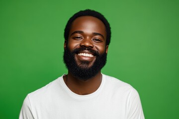 Fototapeta premium Smiling Bearded Man with a Warm Expression Against Green Background. Generative AI.