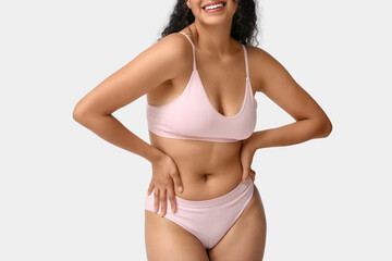 Fototapeta premium Beautiful young happy African-American body positive woman on grey background, closeup