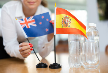 Little flag of Spain on table with bottles of water and flag of Australia put next to it by...