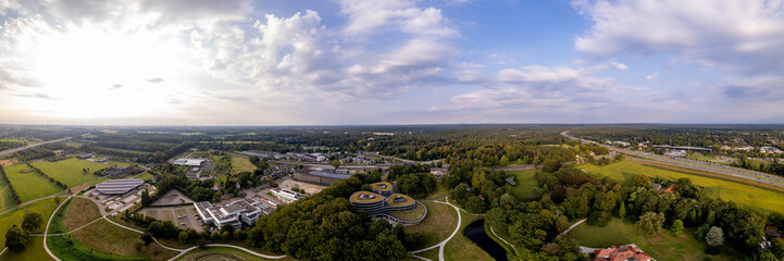 Aerial 180 degree panorama of Triodos bank in green park surrounding of Driebergen Zeist with train station and highway in the background