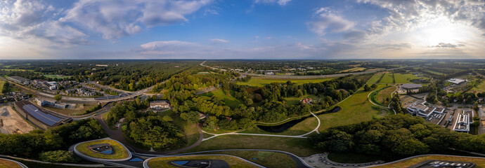 Super wide 180 degrees aerial panorama of Triodos bank in green park surrounding of Driebergen Zeist with train station and highway in the background