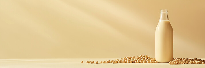 a glass bottle of soy milk with soybeans scattered around against an isolateddusty chocolatebackground