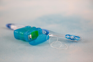 Blue toothbrush and dental floss isolated on the floor